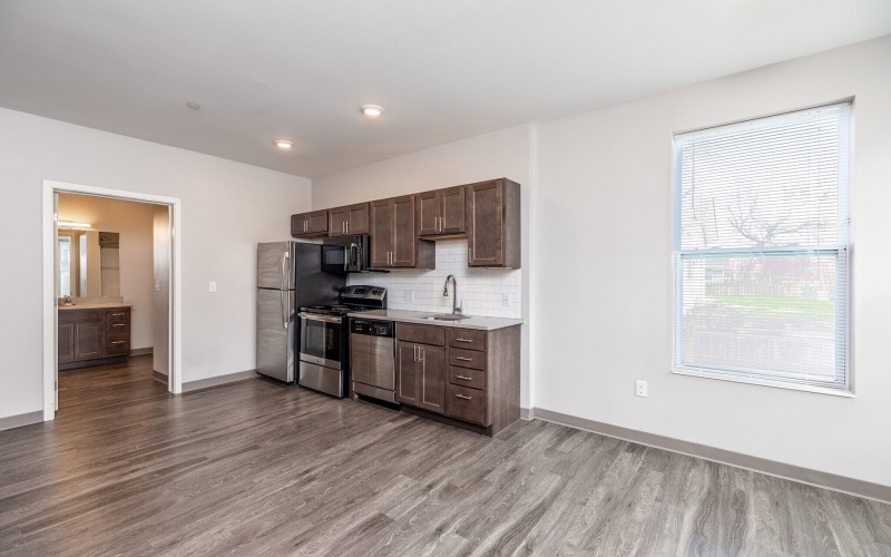a kitchen with wooden cabinets and wood-style flooring