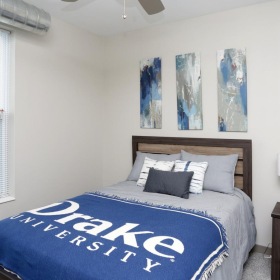 a bedroom with a bed and a fan and a large window